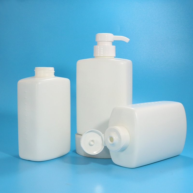 Three white rectangular cosmetic bottles of different sizes arranged against a blue background, representing the kind of finished packaging that needs a clear Incoterm and payment term on every purchase order