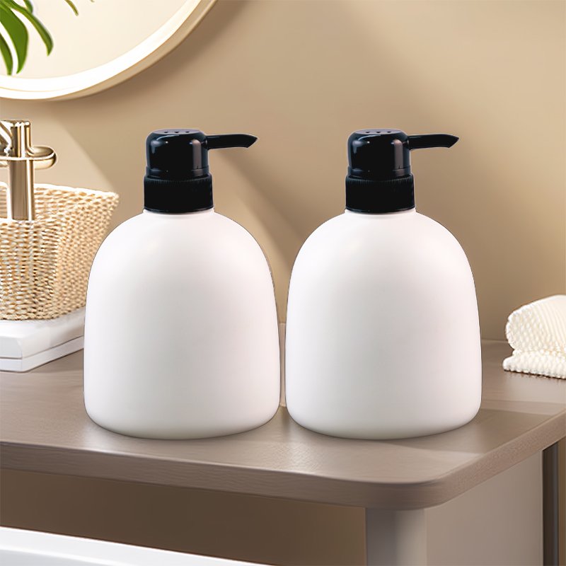 Two white cosmetic bottles with black closures on a bathroom counter, showing the cap and closure assembly that holds the liner or induction seal inside the finish